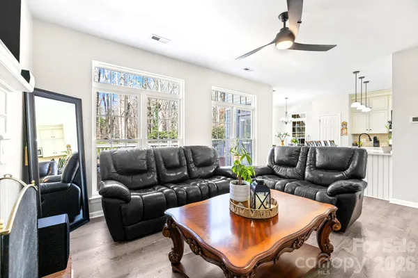 a living room with furniture a large window and a dining table