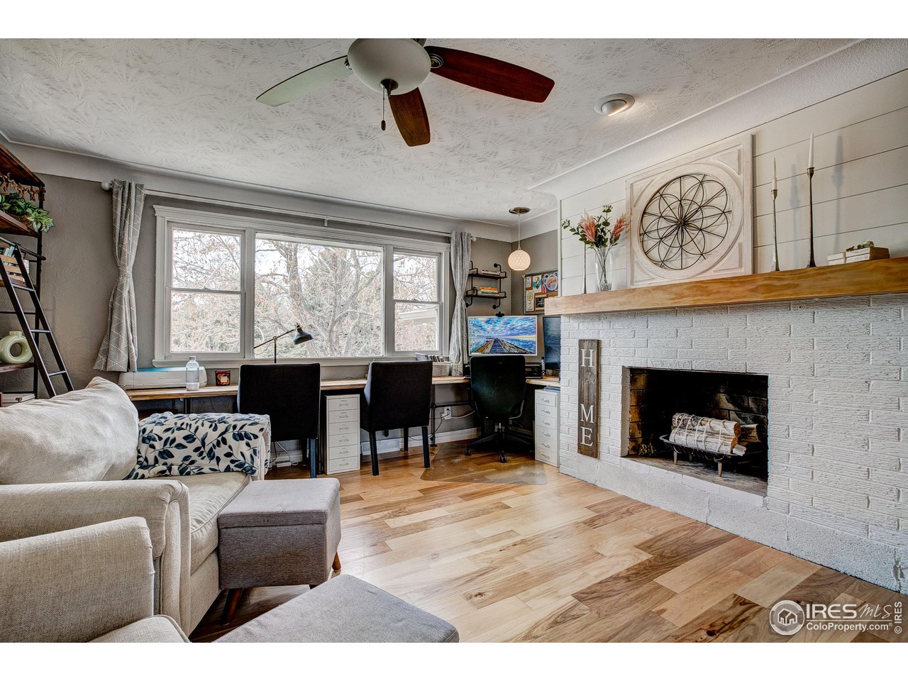 1912 Homestead Road Greeley, CO 80634 - Photo 9 of 40 Living room with wood burning fireplace and massive windows to enjoy your mature trees