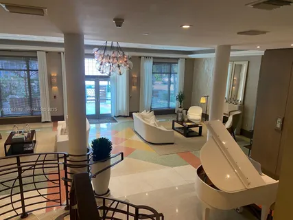 a room with furniture a chandelier and a view of living room