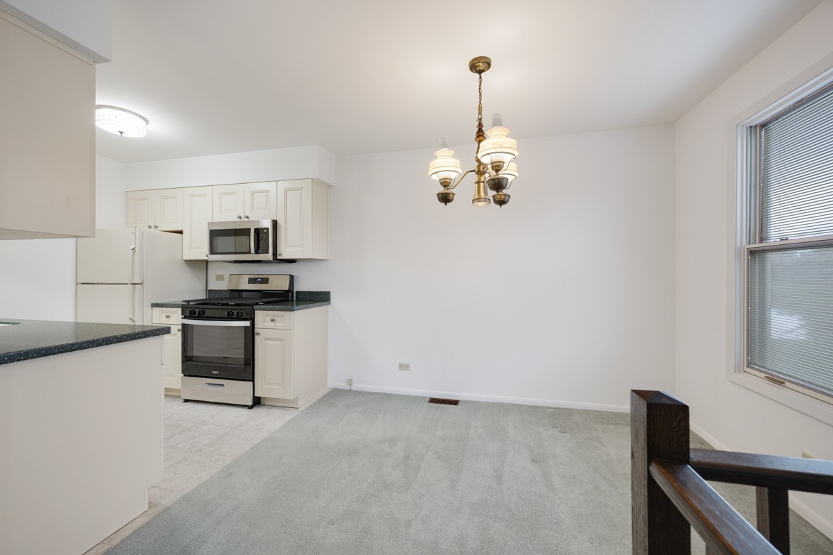 784 Leicester Road Elk Grove Village, IL 60007 - Photo 8 of 27 a kitchen with stainless steel appliances kitchen island a stove and a refrigerator
