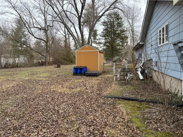 a backyard of a house with table and chairs
