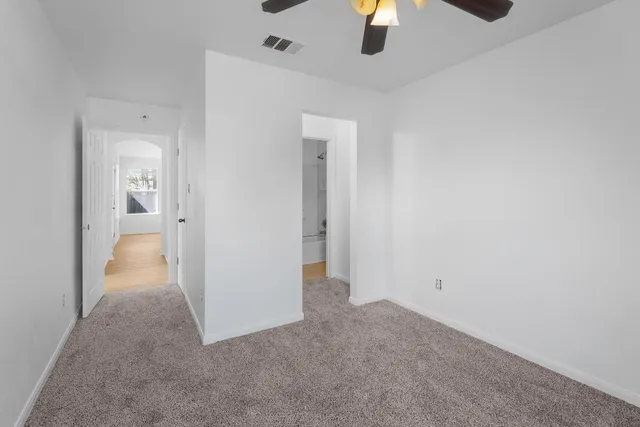 an empty room with fan and entrance