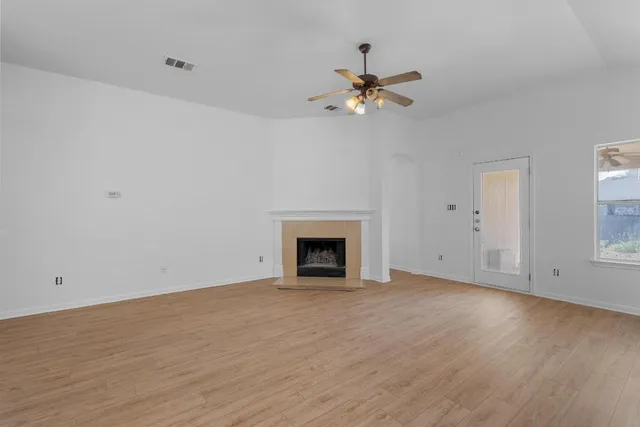 a view of an empty room with a fireplace and a window
