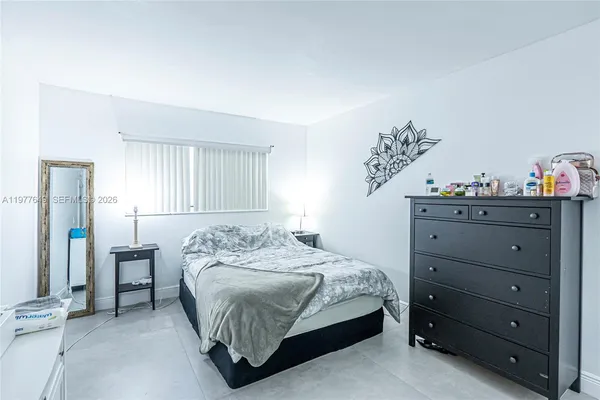 a bedroom with a bed and a dresser in it