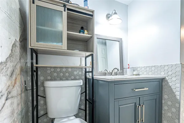 a bathroom with a toilet sink and mirror