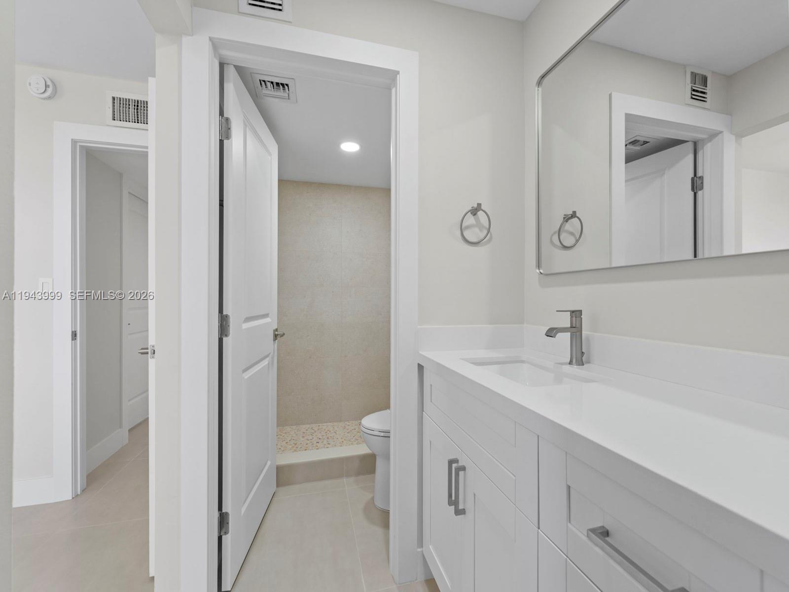 10825 Southwest 112th Avenue, Unit 206 Miami, FL 33176 - Photo 19 of 32 a en suite bathroom with a sink a toilet and a mirror