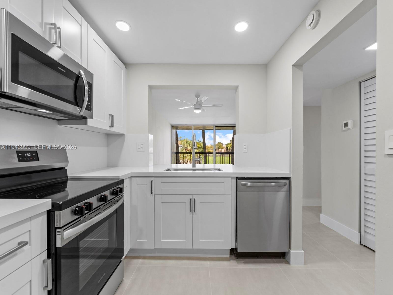 10825 Southwest 112th Avenue, Unit 206 Miami, FL 33176 - Photo 2 of 32 a kitchen with a sink stove and microwave
