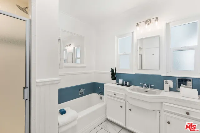 a bathroom with a sink vanity tub and mirror