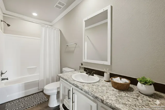 a bathroom with a granite countertop sink a toilet a shower and a mirror