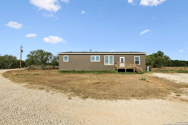 a view of a house with backyard and trees