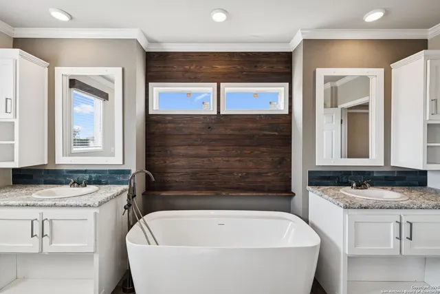 a bathroom with a granite countertop tub sink and mirror