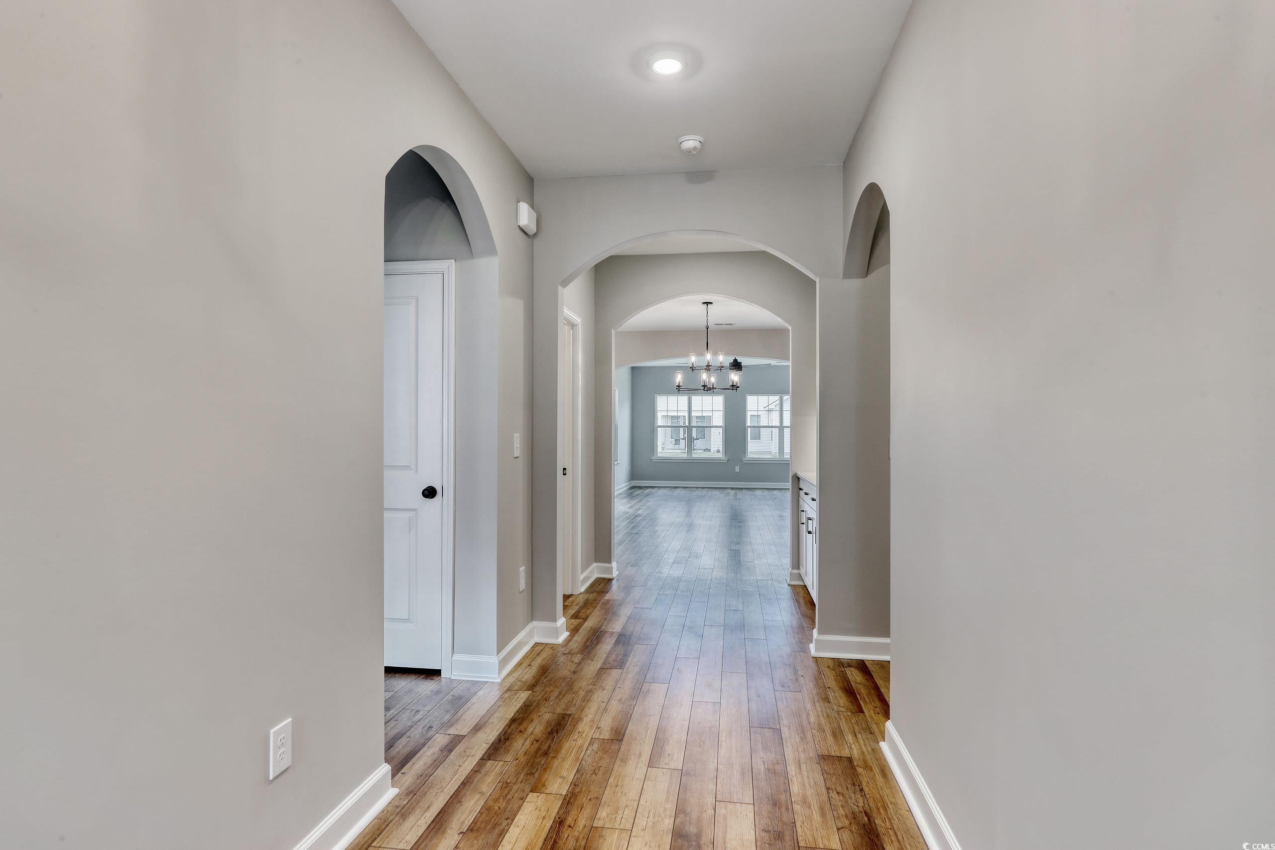 Hallway with hardwood / wood-style flooring and a