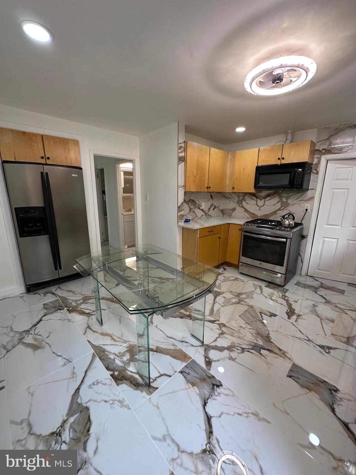 682 Rennard Street Philadelphia, PA 19116 - Photo 13 of 24 a kitchen with stainless steel appliances granite countertop a stove a sink and a refrigerator