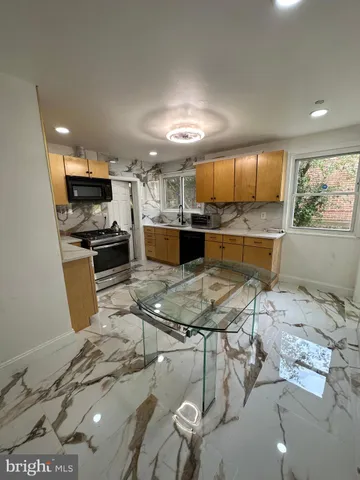 a kitchen with stainless steel appliances kitchen island granite countertop a sink and cabinets