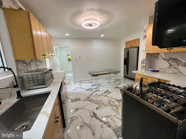 a kitchen with stainless steel appliances a sink stove and cabinets