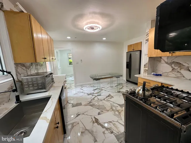 a kitchen with stainless steel appliances kitchen island granite countertop a stove and a sink