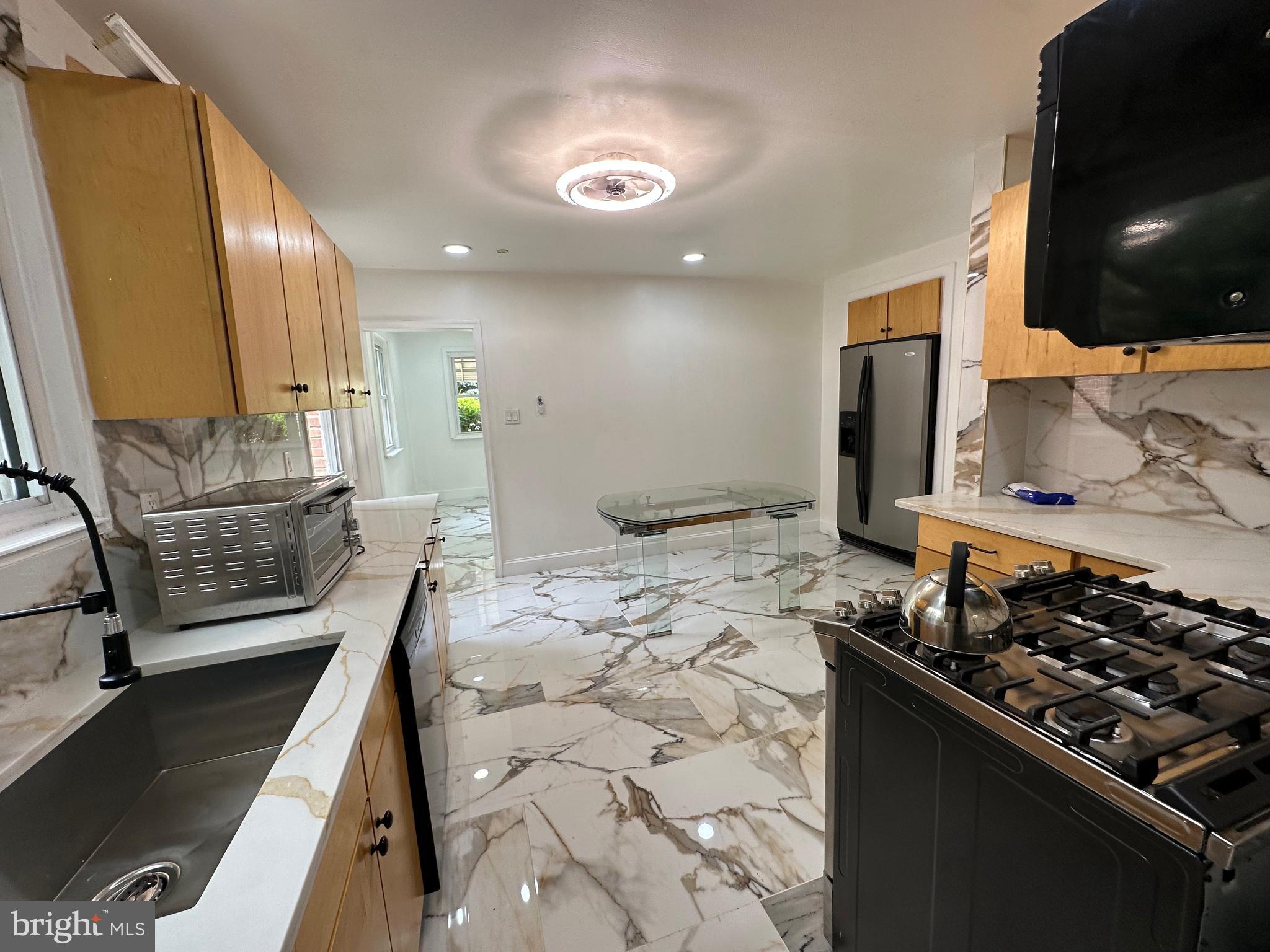 682 Rennard Street Philadelphia, PA 19116 - Photo 18 of 24 a kitchen with stainless steel appliances kitchen island granite countertop a stove and a sink