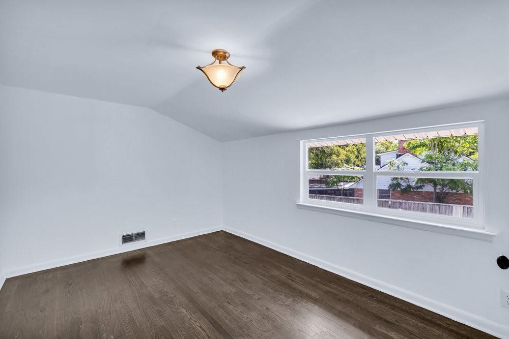 312 West Rio Grande Street Garland, TX 75041 - Photo 13 of 35 an empty room with wooden floor and window