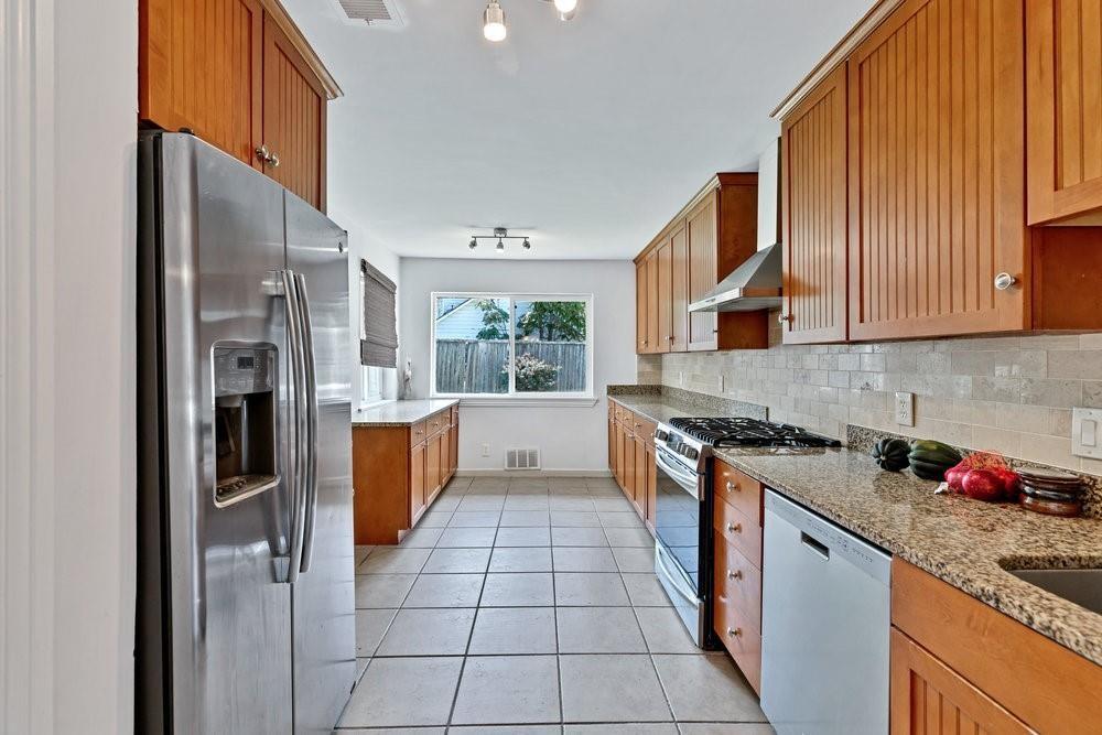 312 West Rio Grande Street Garland, TX 75041 - Photo 9 of 35 a kitchen with stainless steel appliances granite countertop a stove a sink and a refrigerator