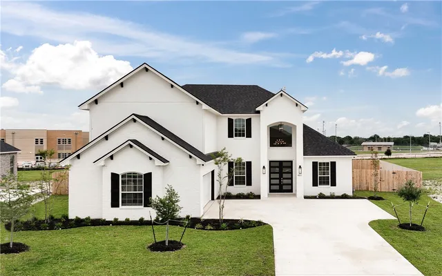 a front view of a house with a yard and garage