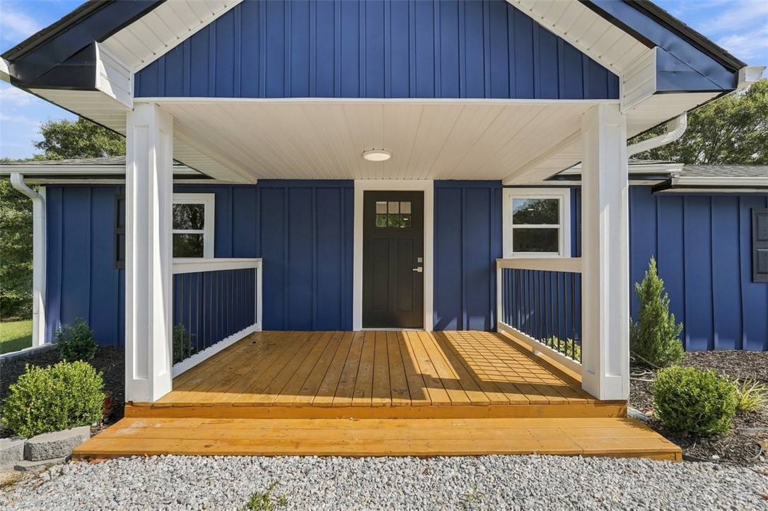 418 Old River Road Pelzer, SC 29669 - Photo 27 of 32 Welcoming front porch features warm wood decking and classic columns under a gabled roofline.