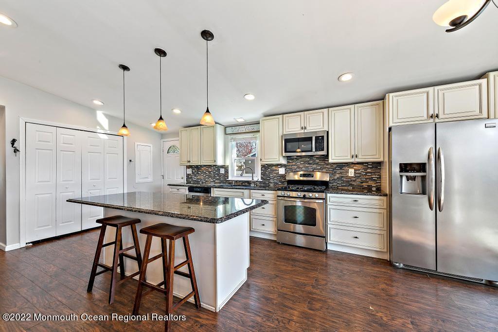 36 Cabana Drive Brick, NJ 08723 - Photo 13 of 42 a kitchen with stainless steel appliances kitchen island granite countertop a stove a sink a refrigerator and a wooden floor
