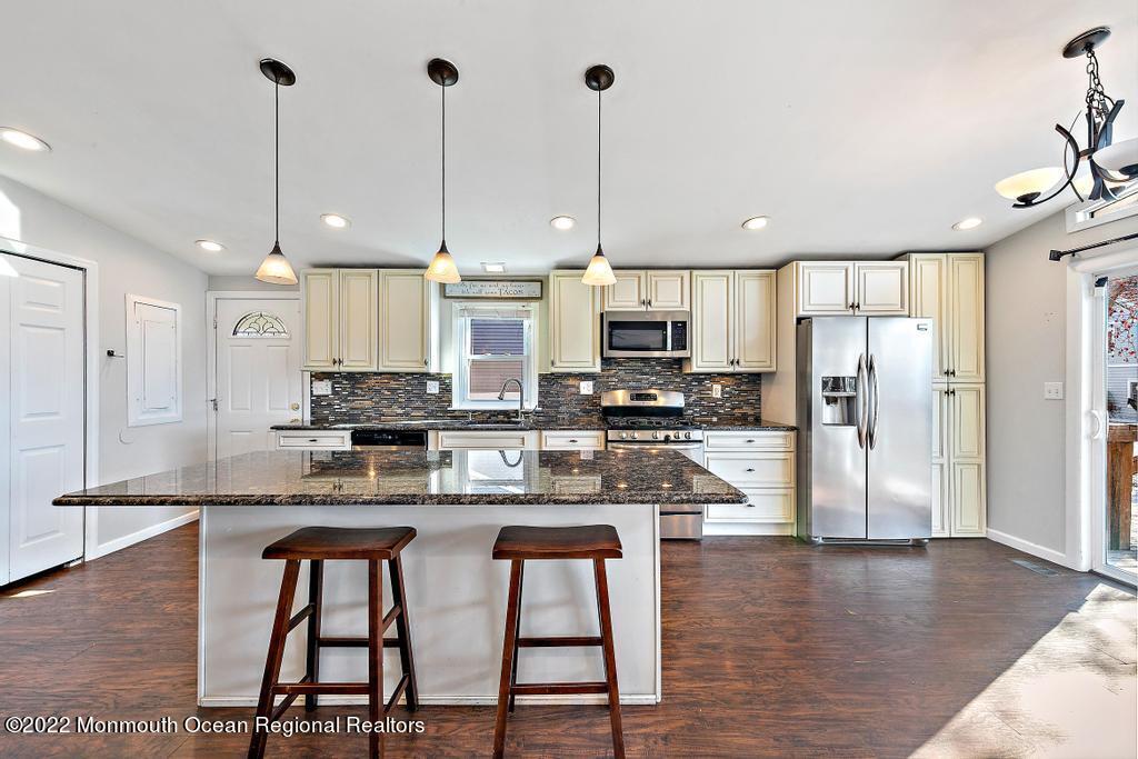 36 Cabana Drive Brick, NJ 08723 - Photo 19 of 42 a kitchen with stainless steel appliances granite countertop a refrigerator a stove top oven a sink island and chairs