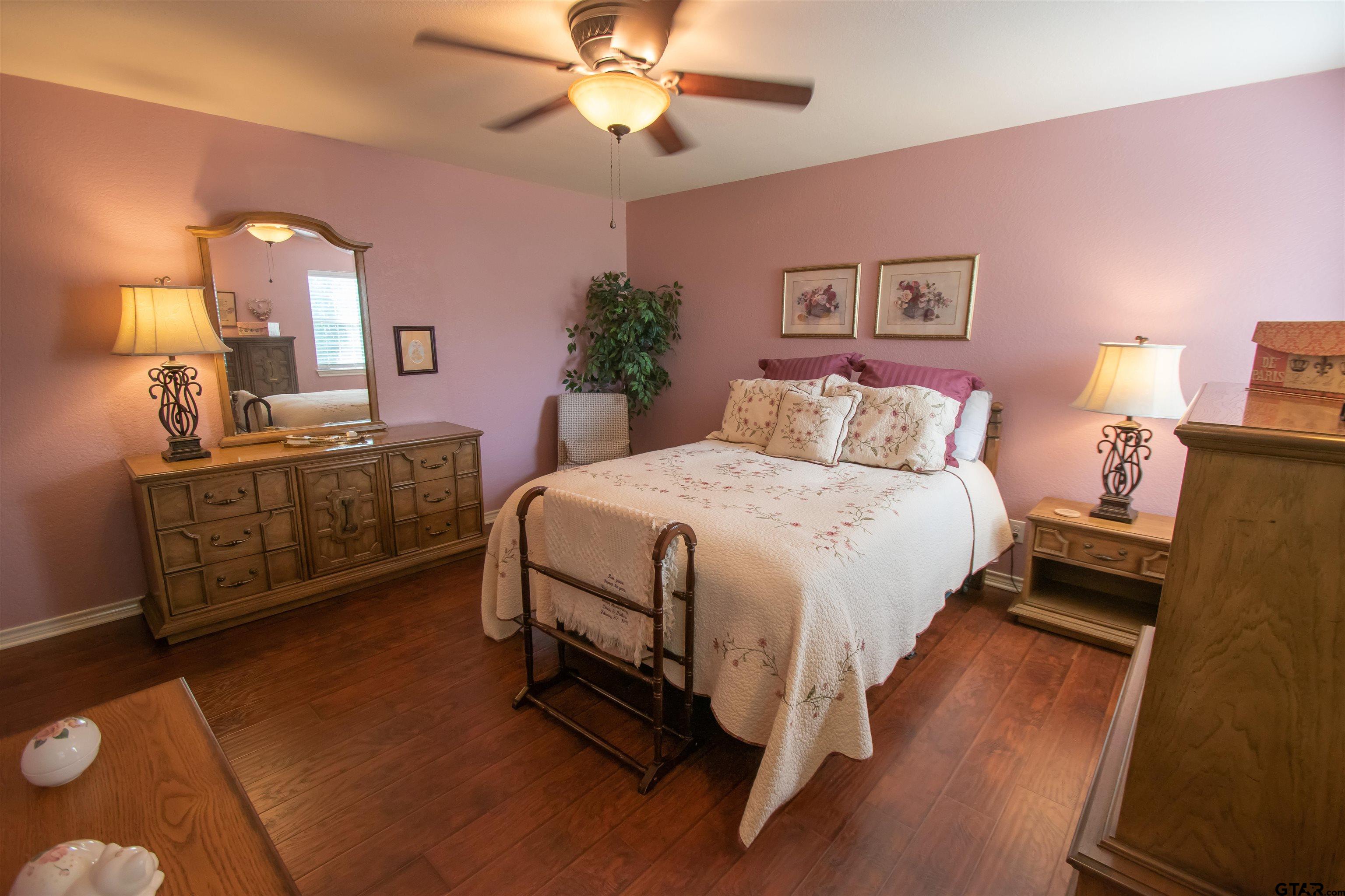 23120 Saddle Ridge Court Lindale, TX 75771 - Photo 21 of 37 a bedroom with a bed and a chandelier