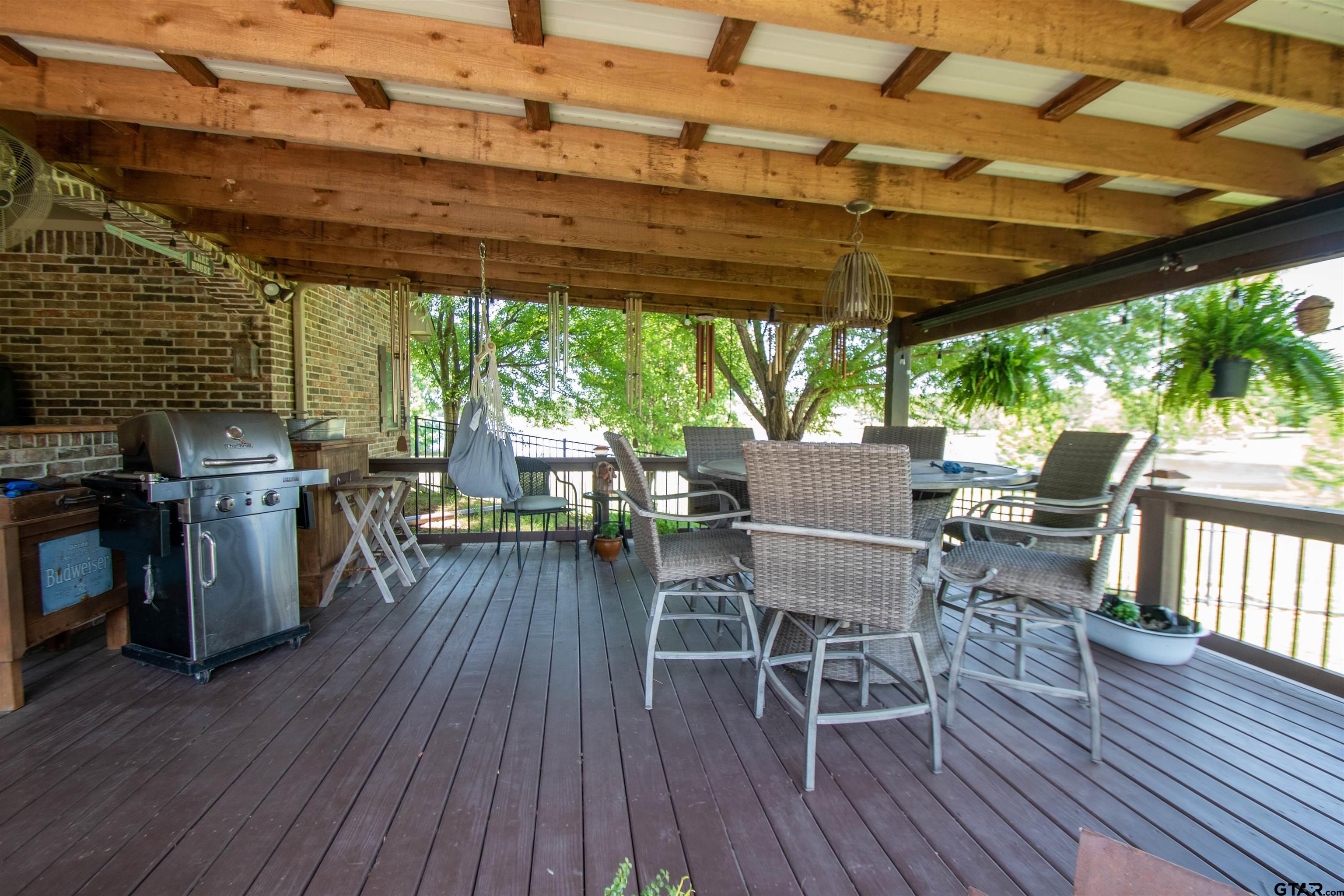 23120 Saddle Ridge Court Lindale, TX 75771 - Photo 29 of 37 a patio with wooden floor a yard a table and chairs