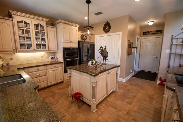 a kitchen that has a lot of cabinets in it and stainless steel appliances