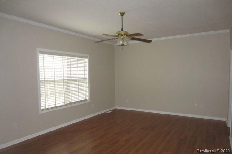 6716 Love Point Road Denver, NC 28037 - Photo 11 of 19 an empty room with wooden floor chandelier fan and windows