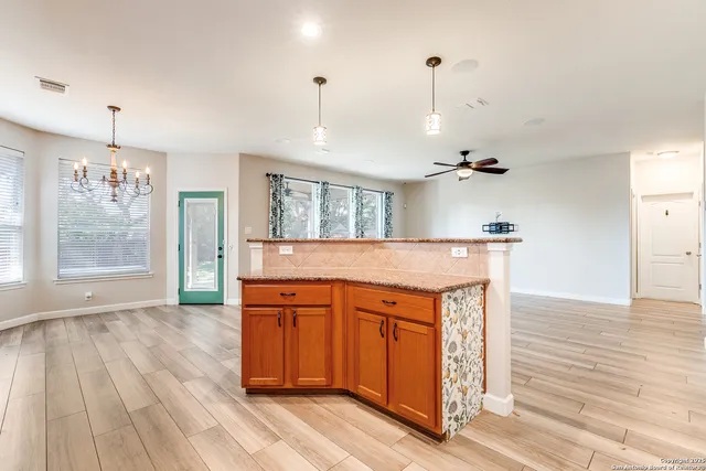 a kitchen with granite countertop wooden cabinets a sink and dishwasher