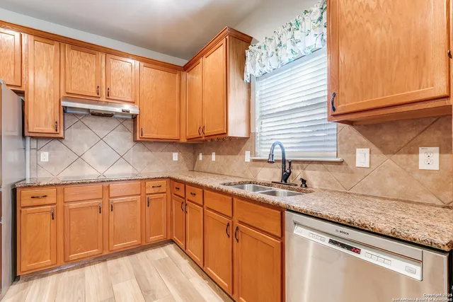 a kitchen with stainless steel appliances granite countertop a stove sink microwave and refrigerator