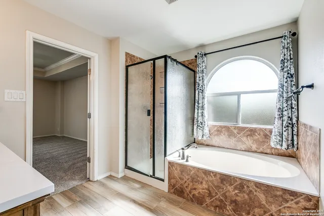 an empty room with chandelier fan and windows