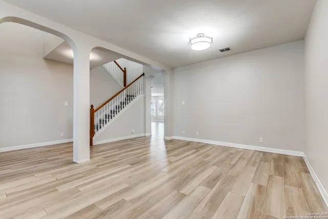 a view of a room with wooden floor chandelier and windows