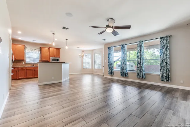 a view of a room with wooden floor and a ceiling fan