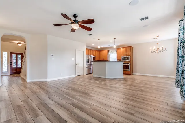 a view of an empty room with a window and wooden floor