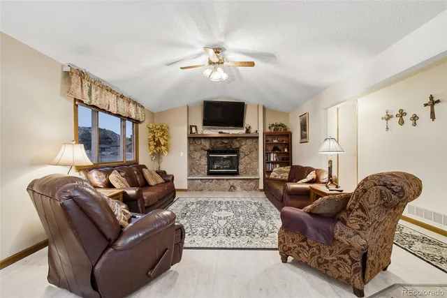 a living room with furniture a flat screen tv and a fireplace
