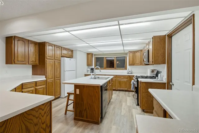 a kitchen with kitchen island a stove a sink and a refrigerator