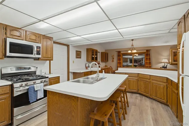 a kitchen with a stove a sink dishwasher a oven with cabinets and wooden floor