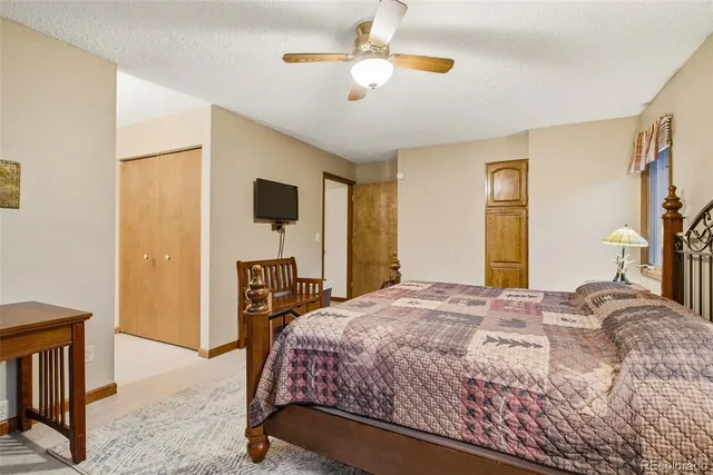 a bedroom with a bed bathroom with a flat tv screen and a dresser