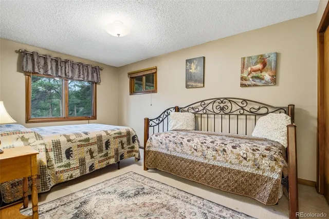 a bedroom with a bed a window and dresser