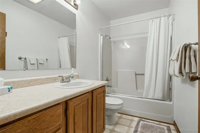 a bathroom with a sink a toilet a mirror and shower