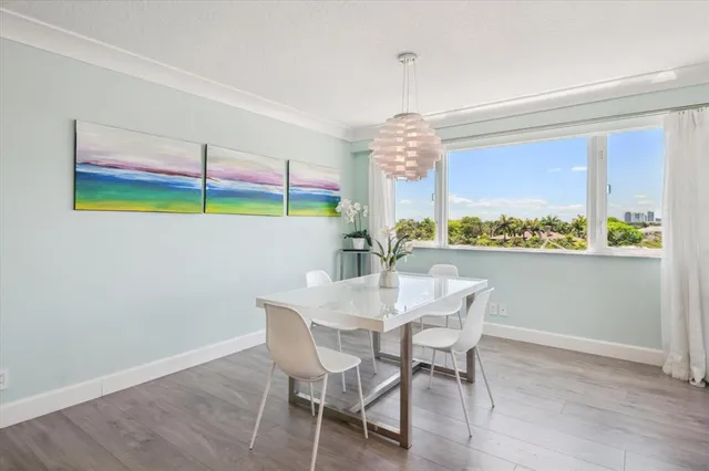 a view of a dining room with furniture a chandelier and wooden floor