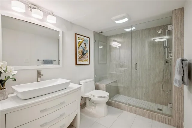 a bathroom with a sink a toilet and shower