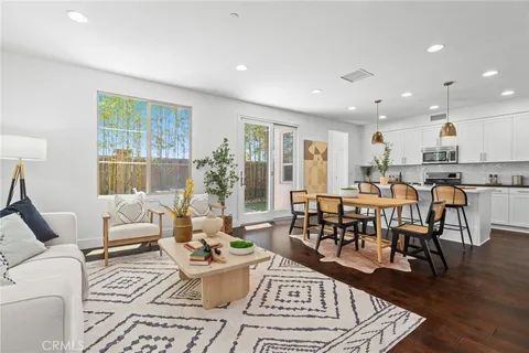 a living room with furniture dining table and a large window
