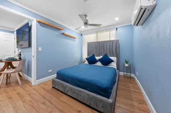 a bedroom with a bed and a wooden floor