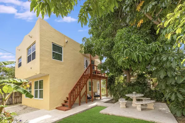 a backyard of a house with barbeque oven table and chairs