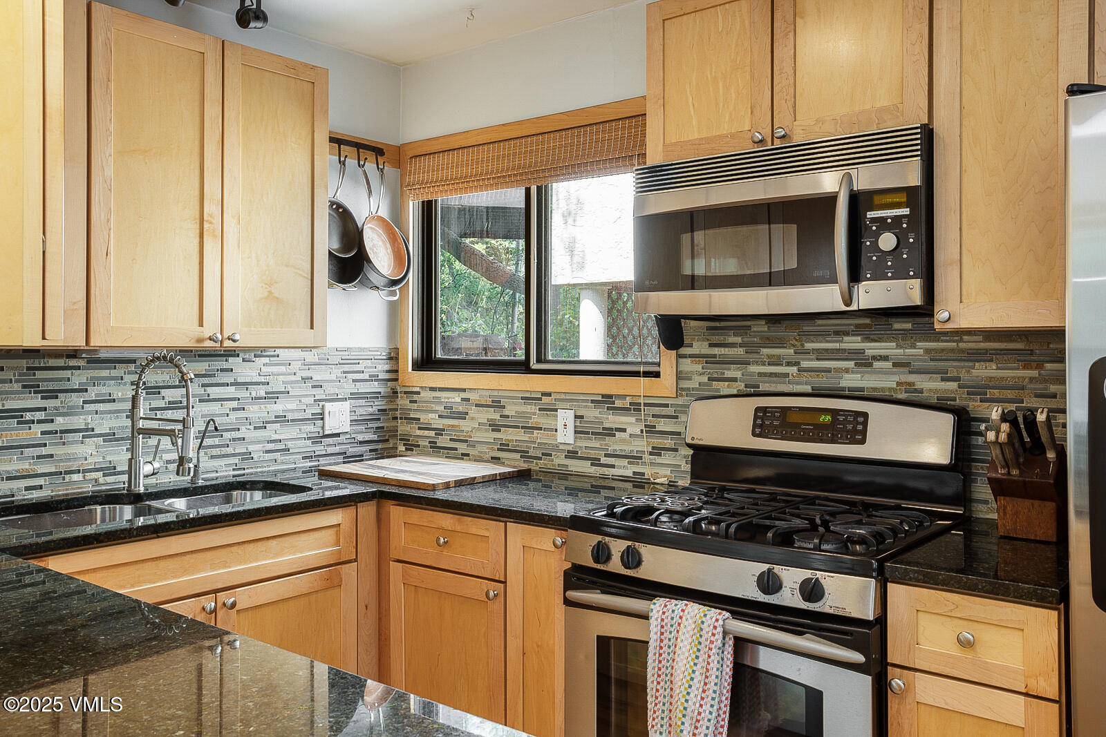 1490 Buffehr Creek Road, Unit A44 Vail, CO 81657 - Photo 9 of 39 a kitchen with granite countertop a stove top oven cabinetry a sink and a window