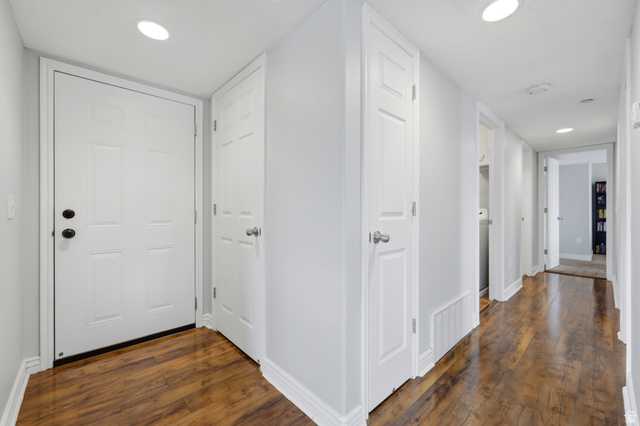 116 East Resaca Drive, Unit F6 Sandy, UT 84070 - Photo 6 of 32 Entryway featuring a white paneled door with black hardware, wood-finish flooring, recessed lighting, and white baseboards